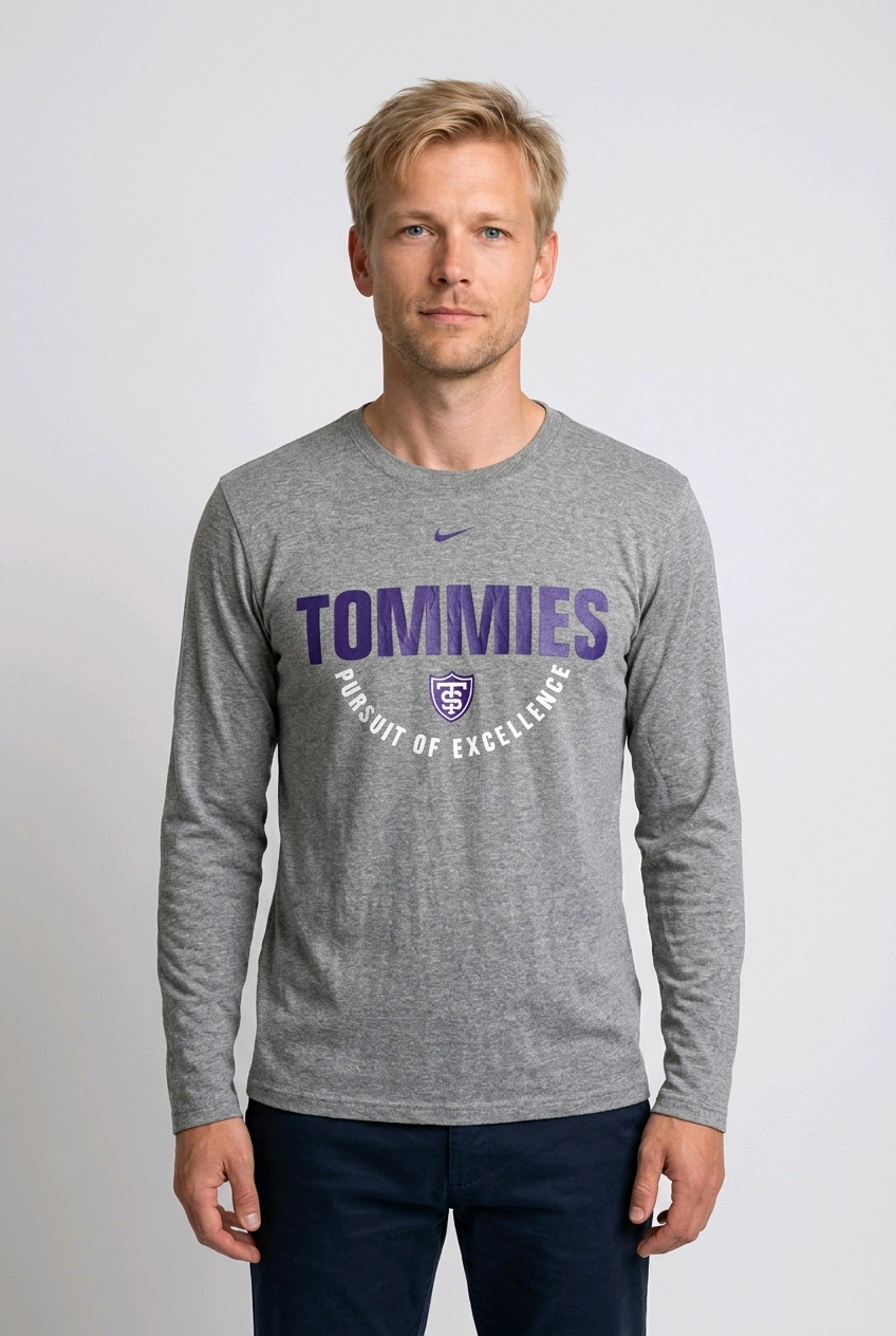 Man wearing a gray long-sleeve shirt with 'Tommies Pursuit of Excellence' text