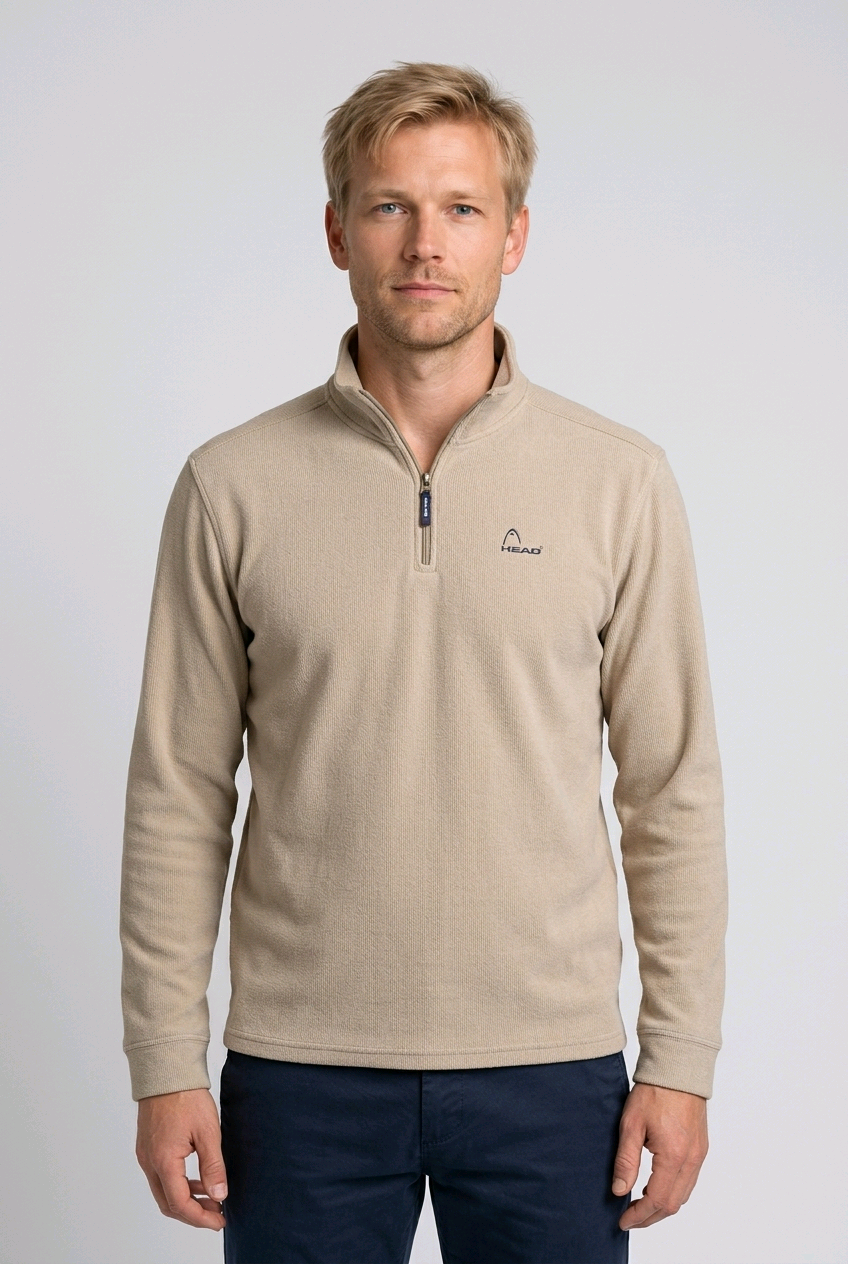 Man wearing a beige long-sleeve sweatshirt with a logo 