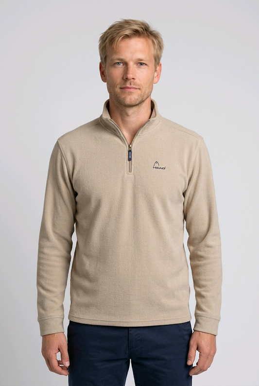 Man wearing a beige long-sleeve sweatshirt with a logo 