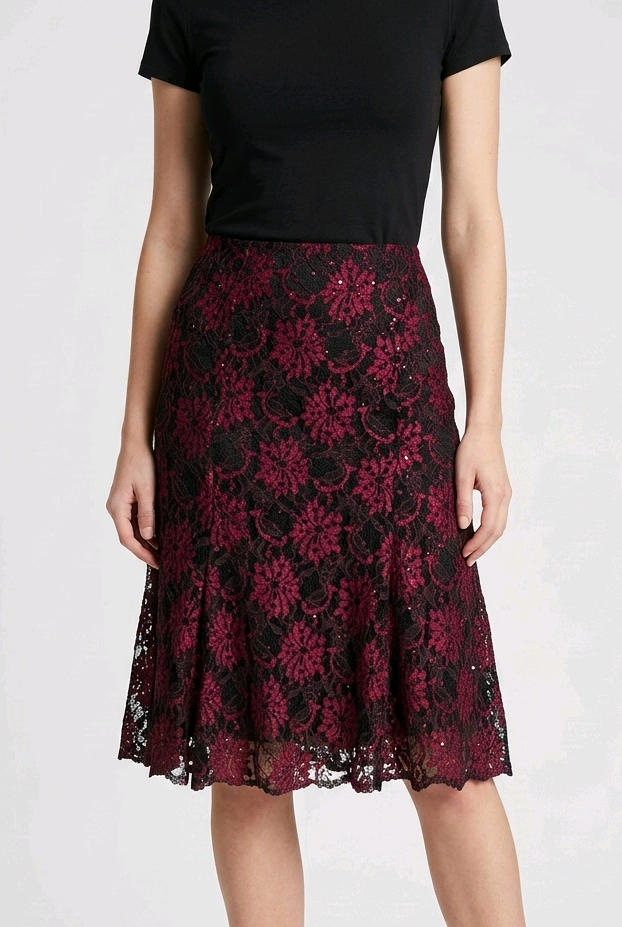 Woman wearing a black top and red floral lace skirt 