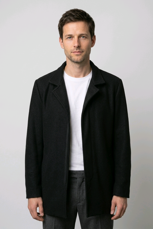 Man wearing a black coat over a white shirt 