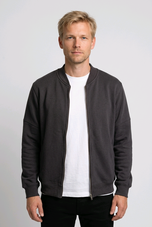Man wearing a dark gray zip up sweatshirt over a white shirt