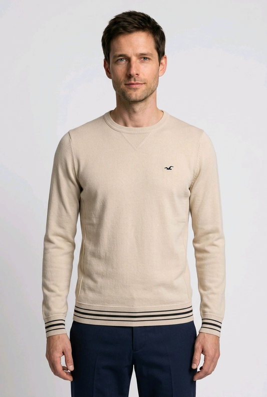 Man wearing a beige sweater with a hollister small logo