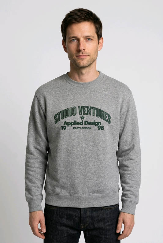 Man wearing a gray sweatshirt with 'Studio Ventures' text 