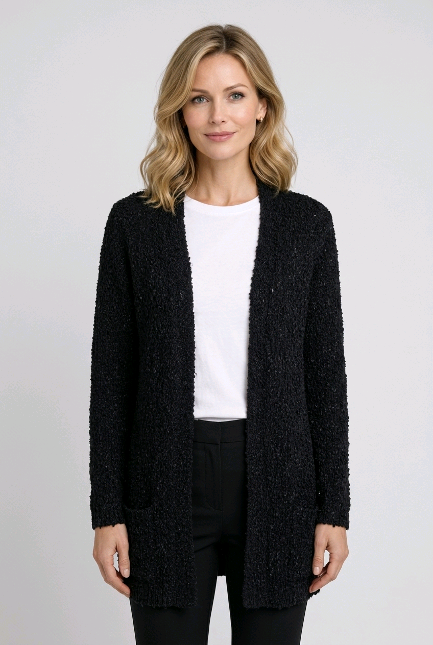 Woman wearing a black textured cardigan over a white top and black jeans