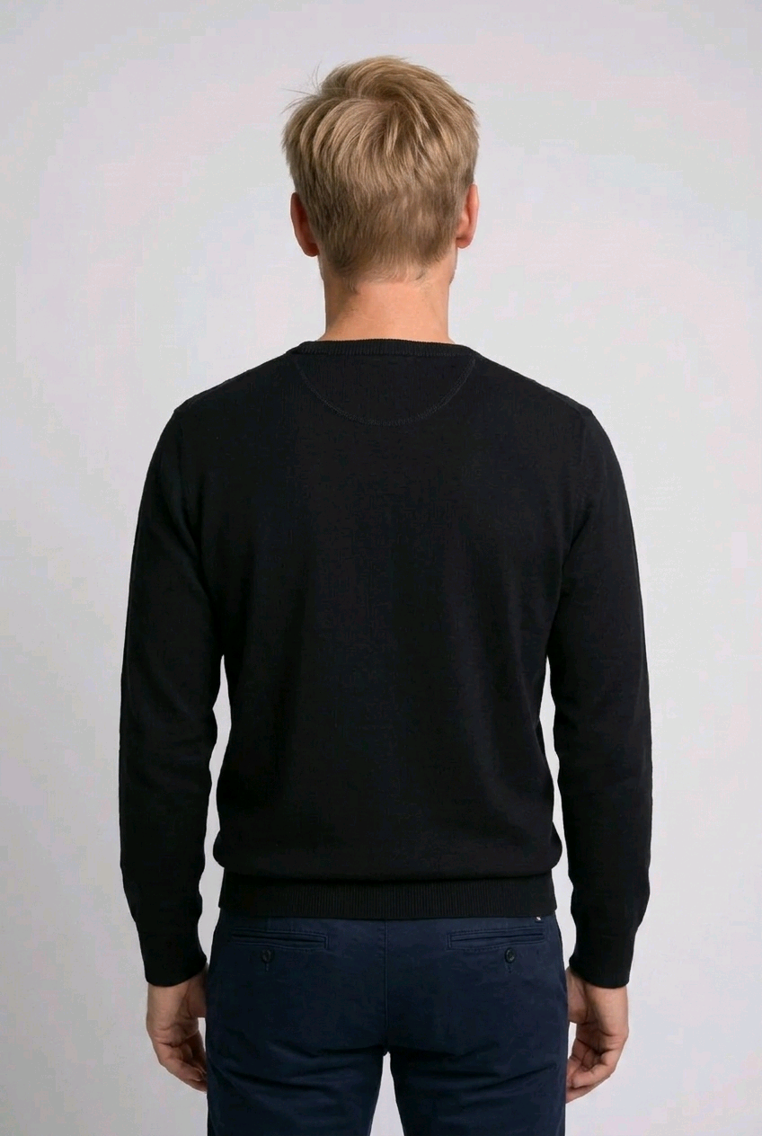 Person wearing a black sweater against a white background