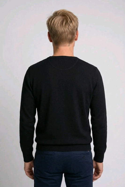 Person wearing a black sweater against a white background