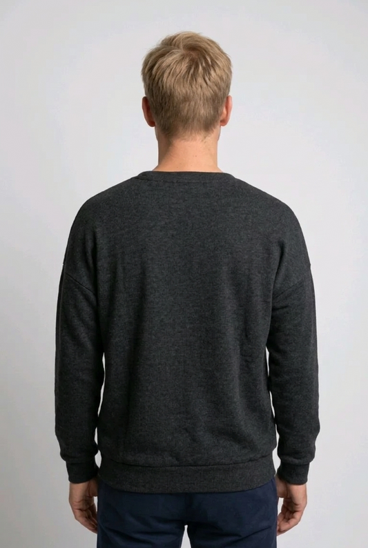 Person wearing a dark gray sweatshirt against a plain background