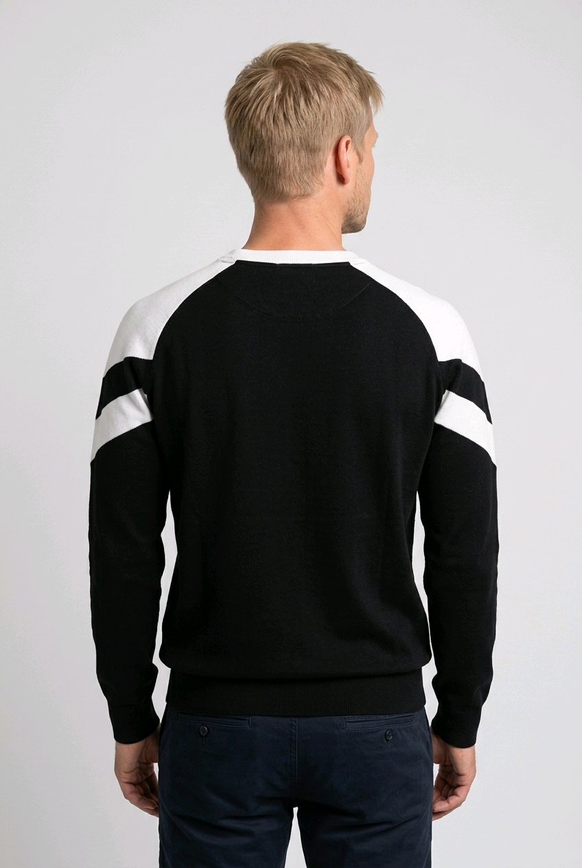 Man wearing a black sweater with white sleeves on a plain background