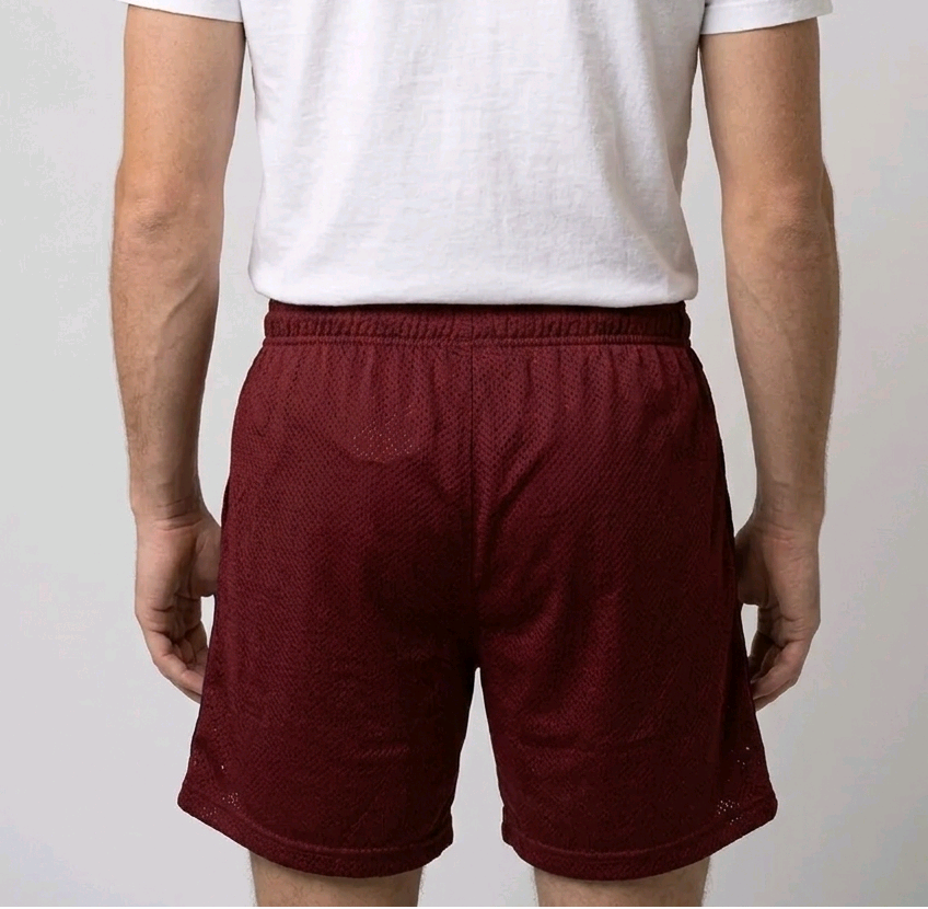 Man wearing red shorts and a white t shirt back view