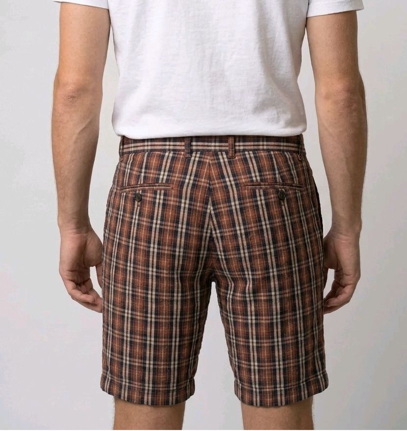 Man wearing a white t-shirt and plaid shorts 