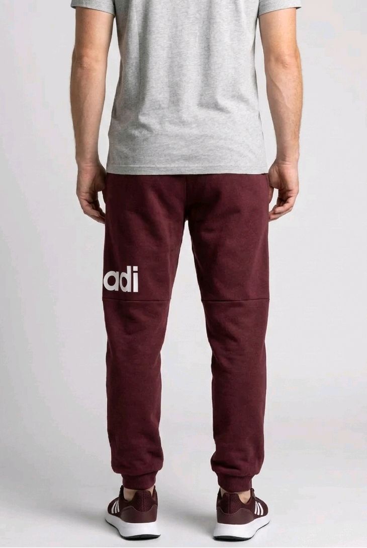 Person wearing maroon Adidas joggers back view