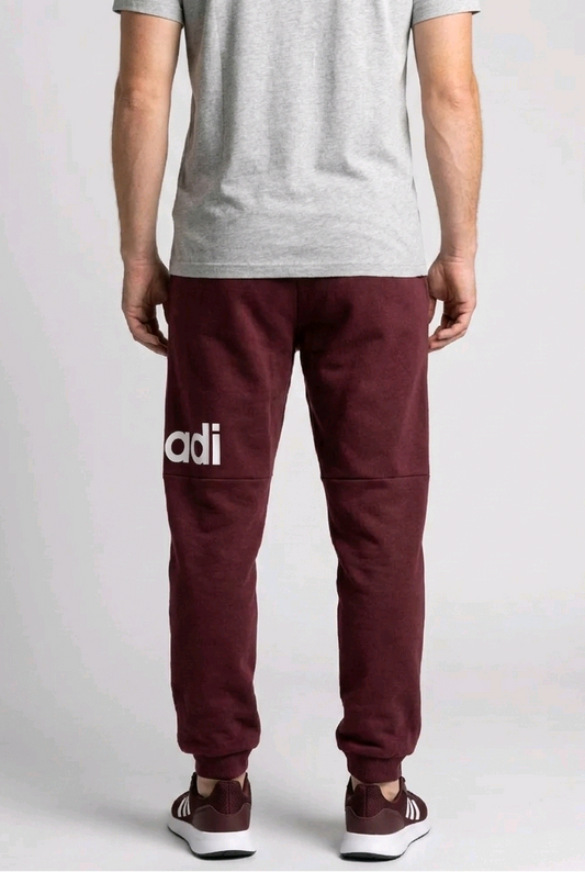 Person wearing maroon Adidas joggers back view