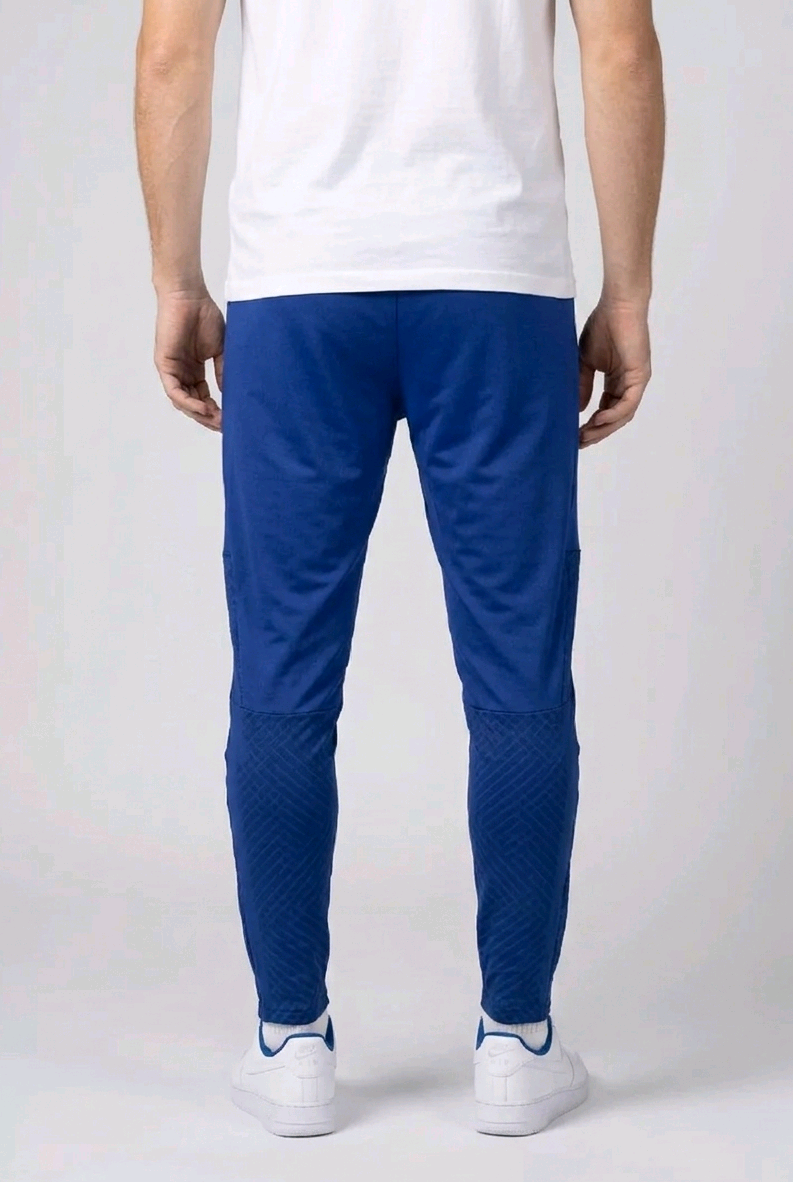 Person wearing blue joggers and white trainers
