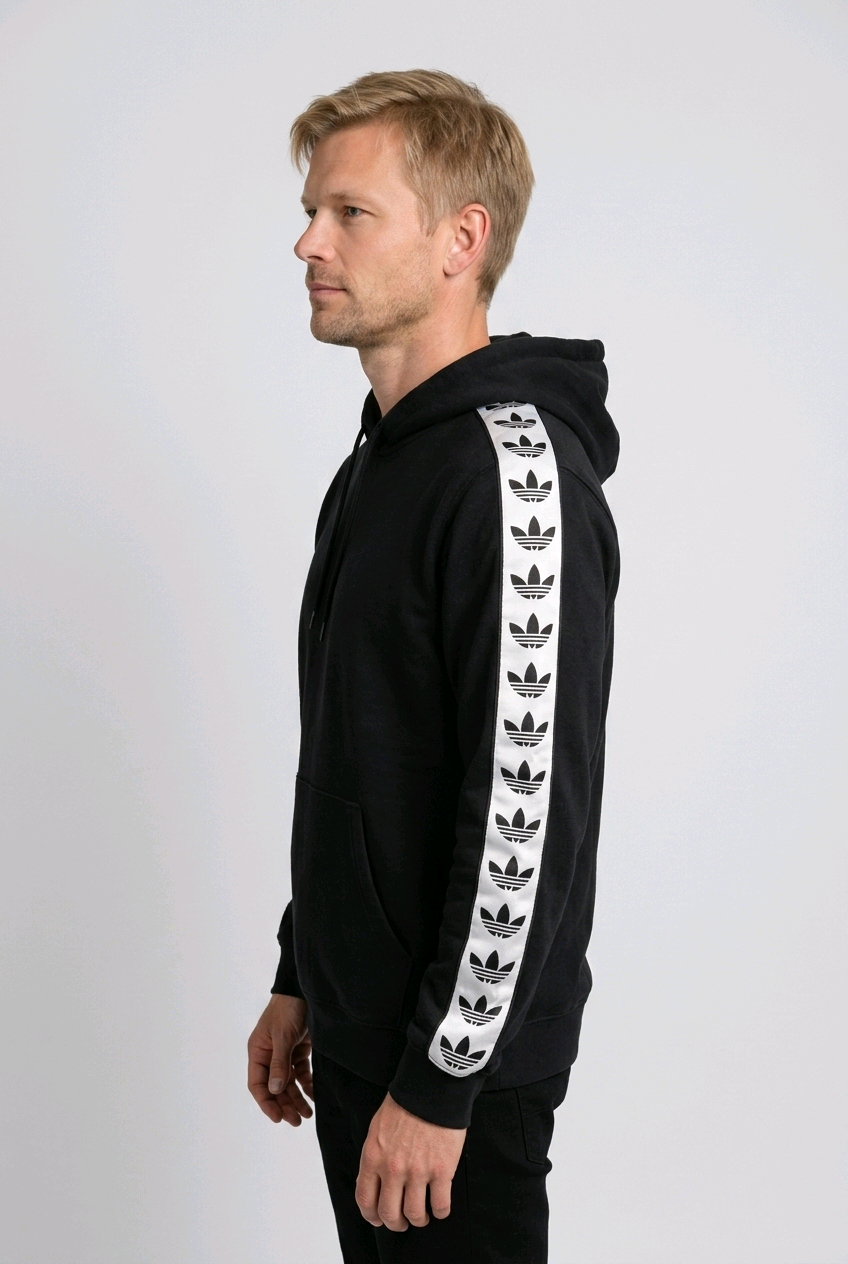 Man wearing a black hoodie with white Adidas taped sleeves