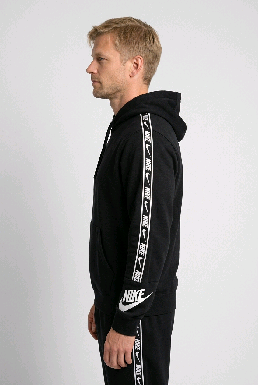 Man wearing a black Nike hoodie and pants with white logo stripes on a 