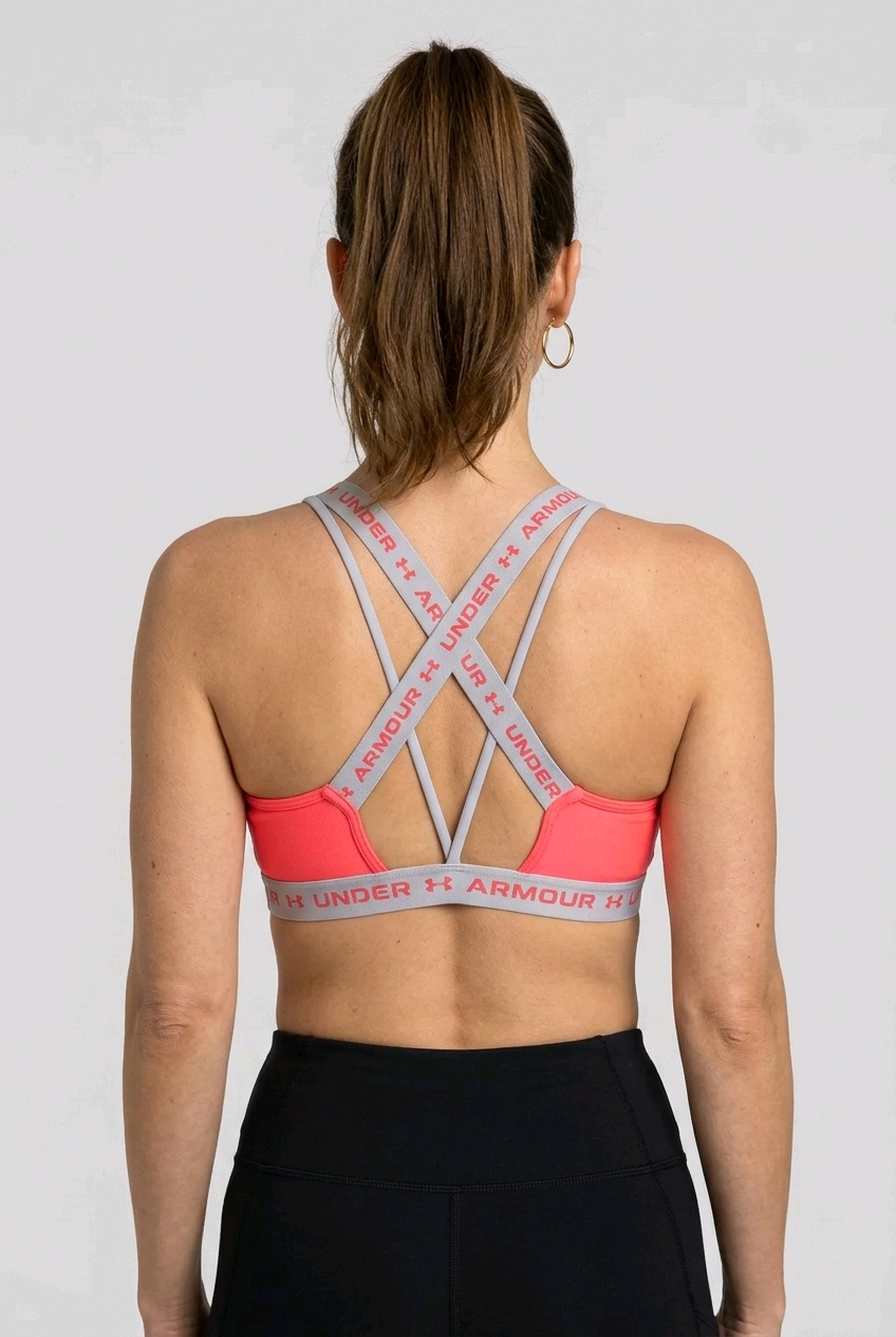 Women wearing a Under Armour pink sports bra back view