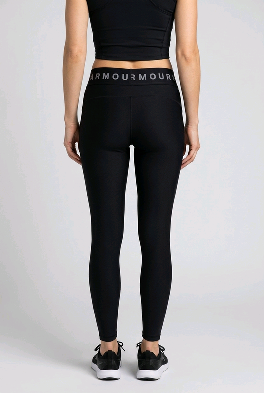 Woman wearing black leggings with 'Armour' branding waistband