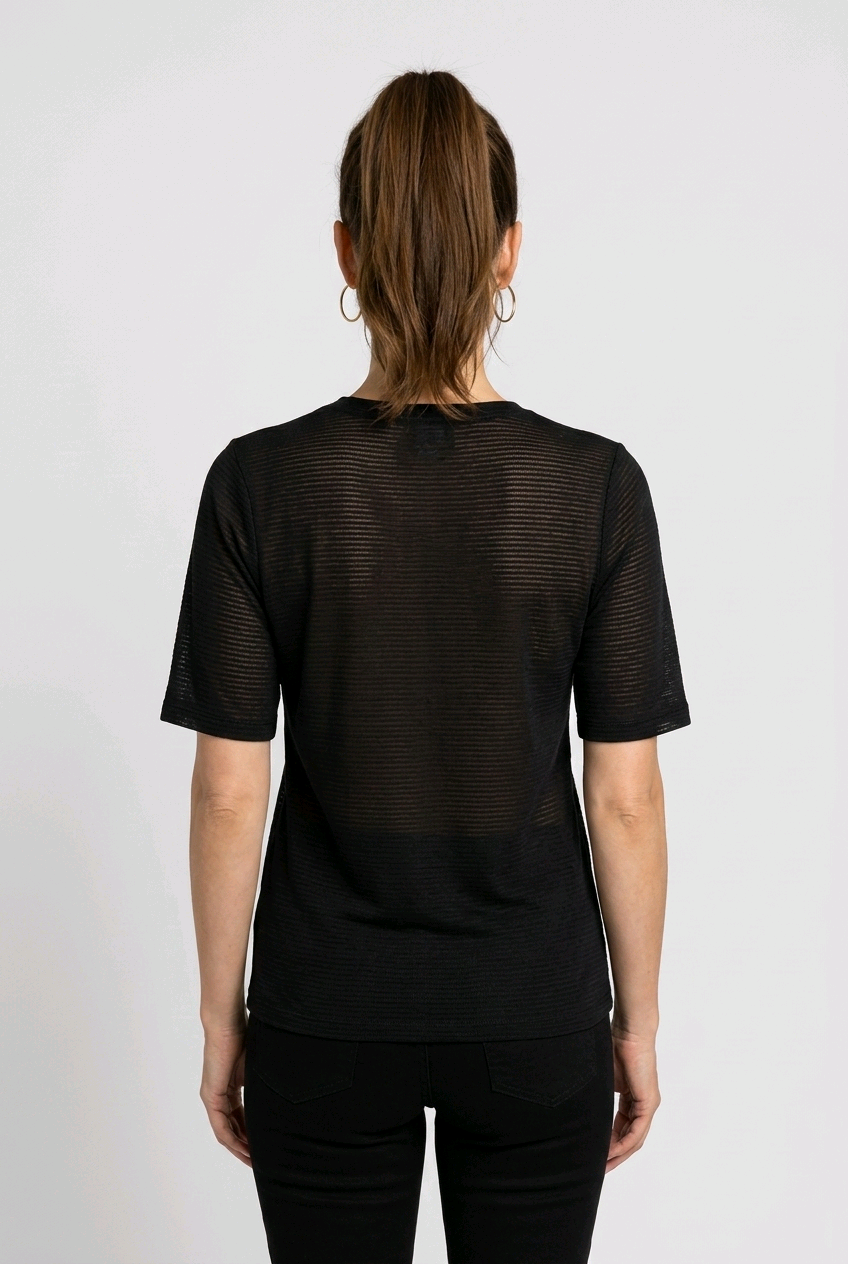 Woman wearing a Nike black textured shirt from behind 