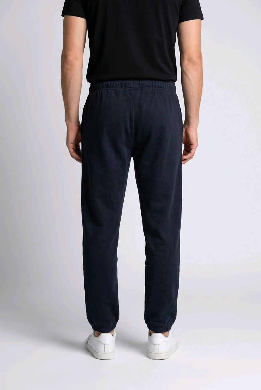 Man wearing black joggers and black t shirt back view