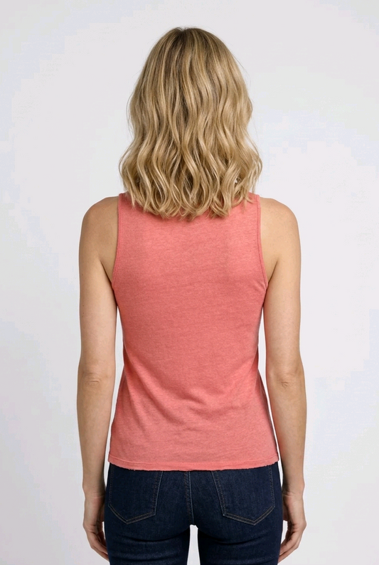 Person wearing a coral tank top and dark jeans