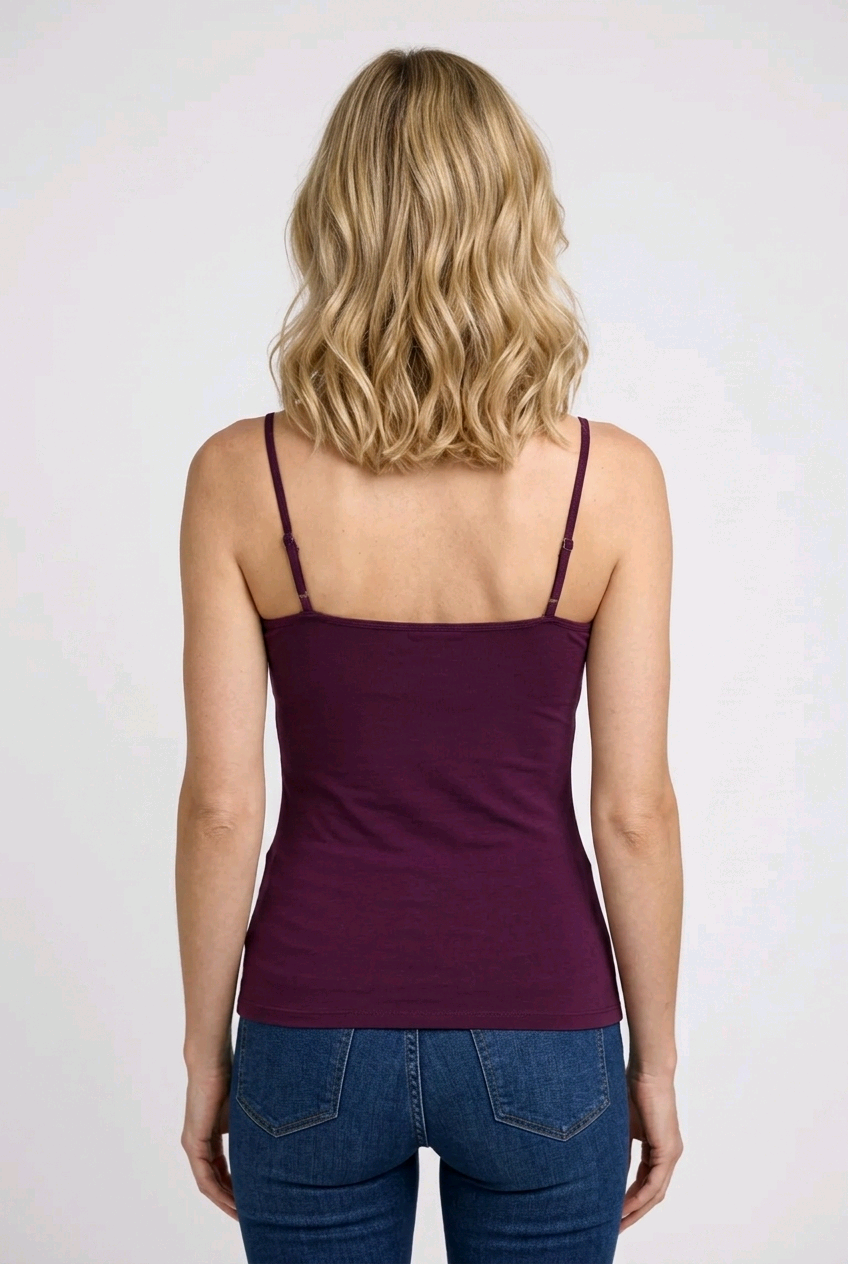 Woman wearing a purple tank top and blue jeans 