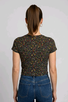 Woman wearing a black floral patterned T-shirt and blue jeans on
