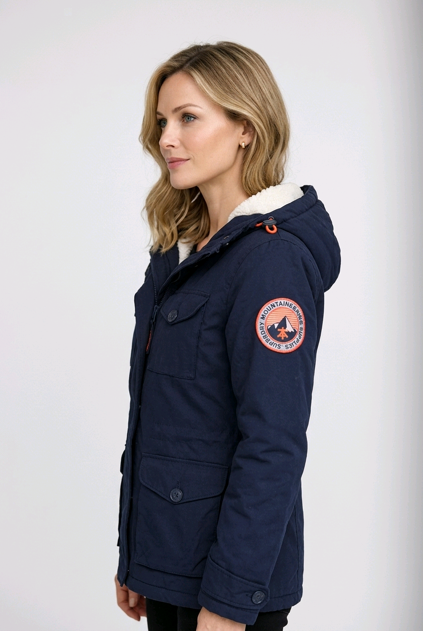 Woman wearing a navy blue jacket with a brand logo 