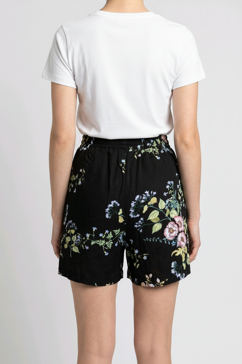 Woman wearing a white t-shirt and black floral shorts 