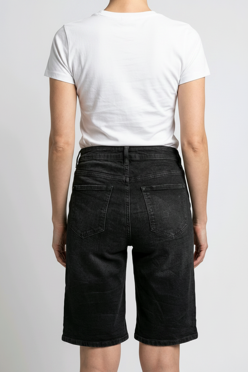 Woman wearing a white t-shirt and black denim shorts 