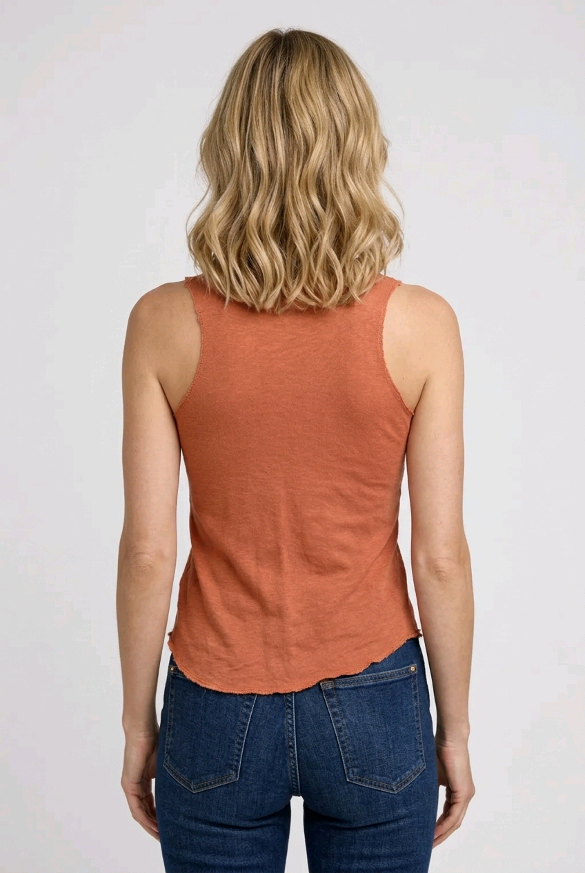 Person wearing a coral tank top and blue jeans