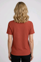 Woman wearing a red textured shirt back view