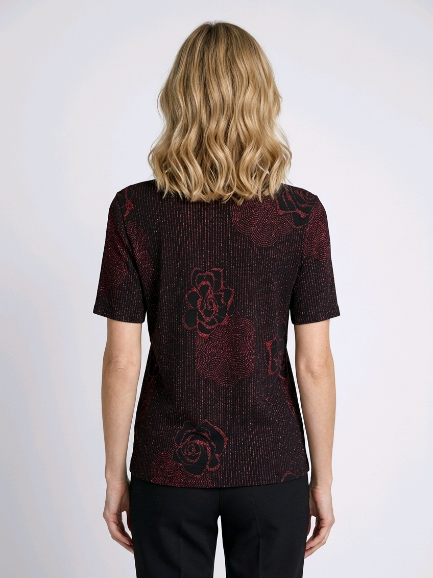 Person wearing a dark red patterned top with floral designs