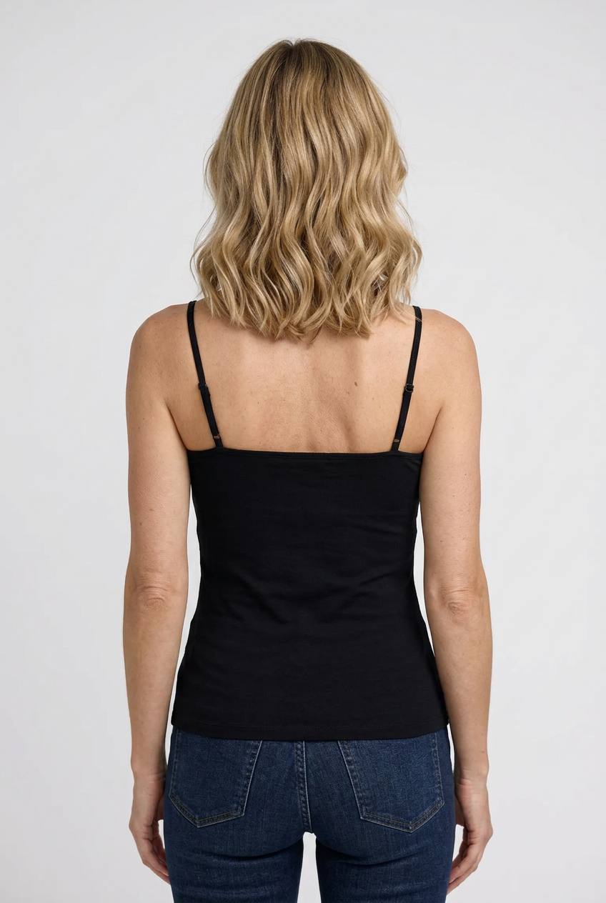 Woman wearing a black cami top and blue jeans back view