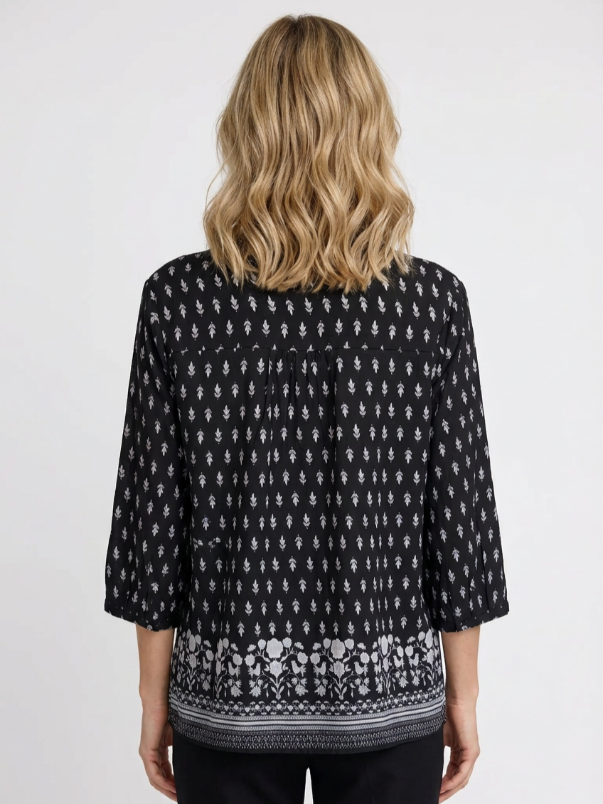 Person wearing a black patterned blouse