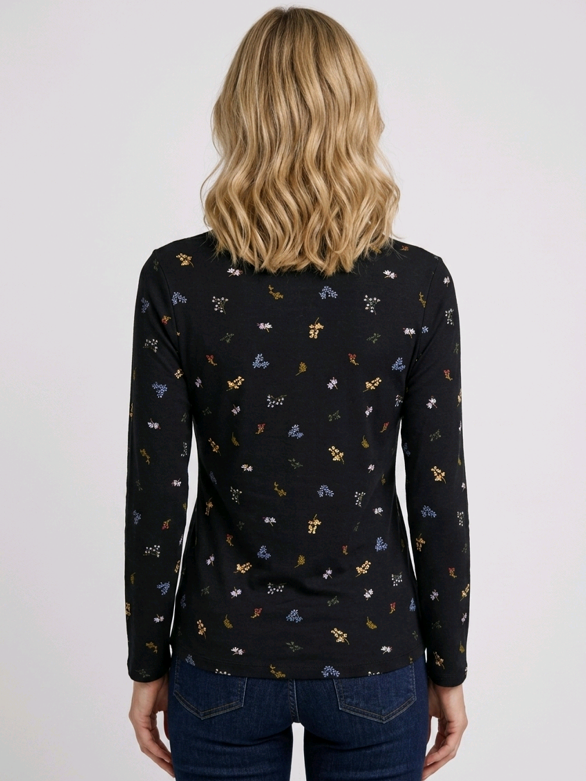 Person wearing a black long-sleeve top with small colourful patterns 