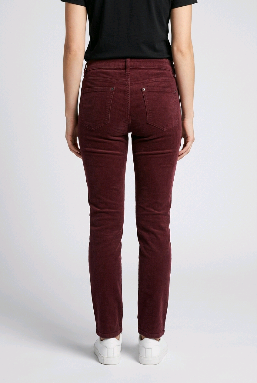 woman wearing maroon pants and a black top on a white background