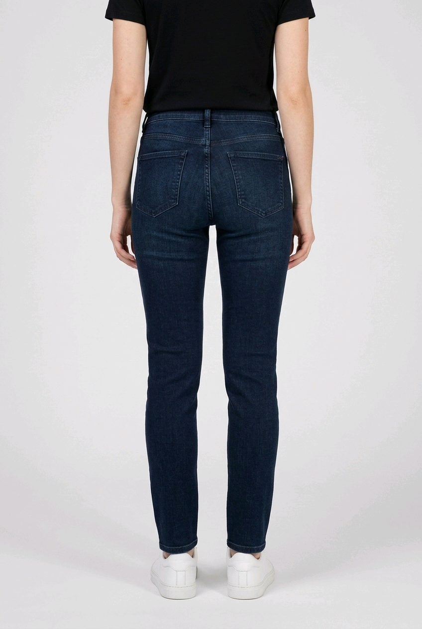 woman wearing dark blue jeans and a black top on a white background