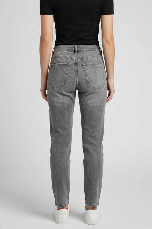 Person wearing gray jeans and a black top on a white background