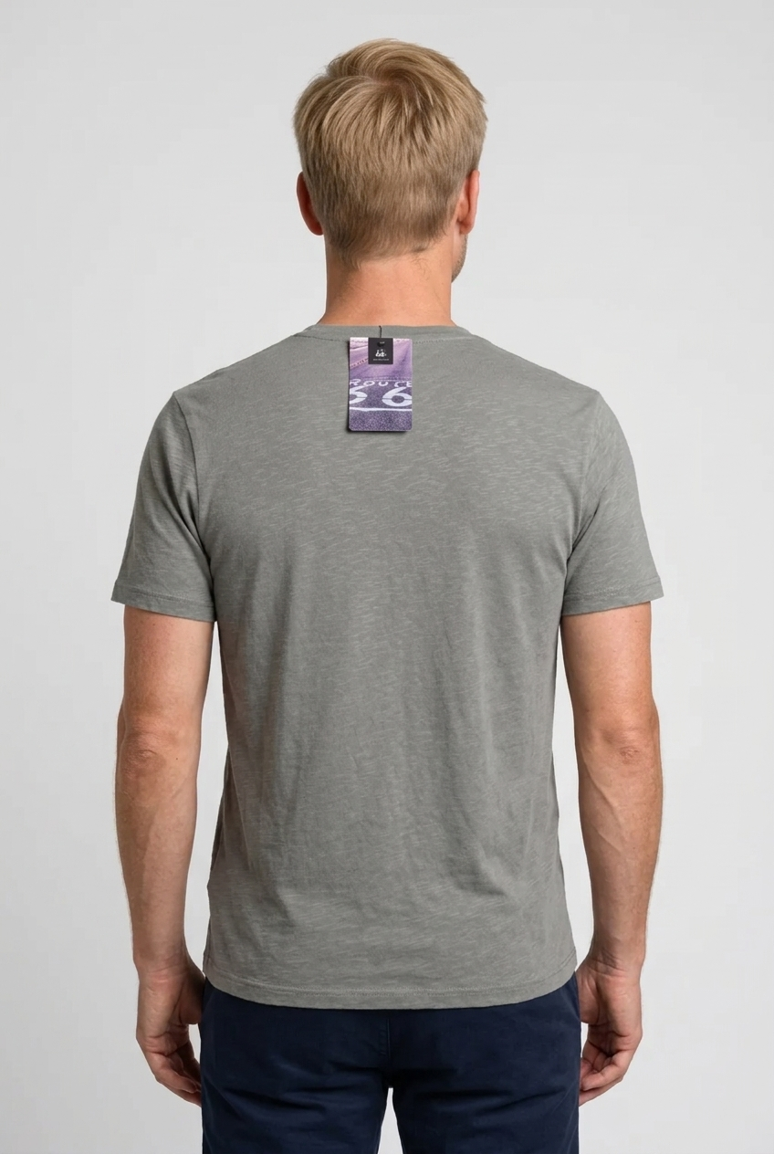 Man wearing a gray t-shirt with a brand label on the back