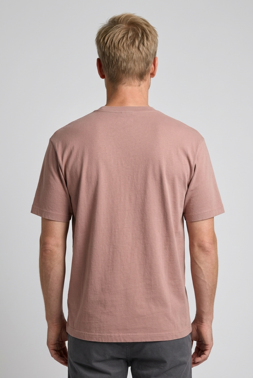Man wearing a dusty rose t-shirt on a plain background