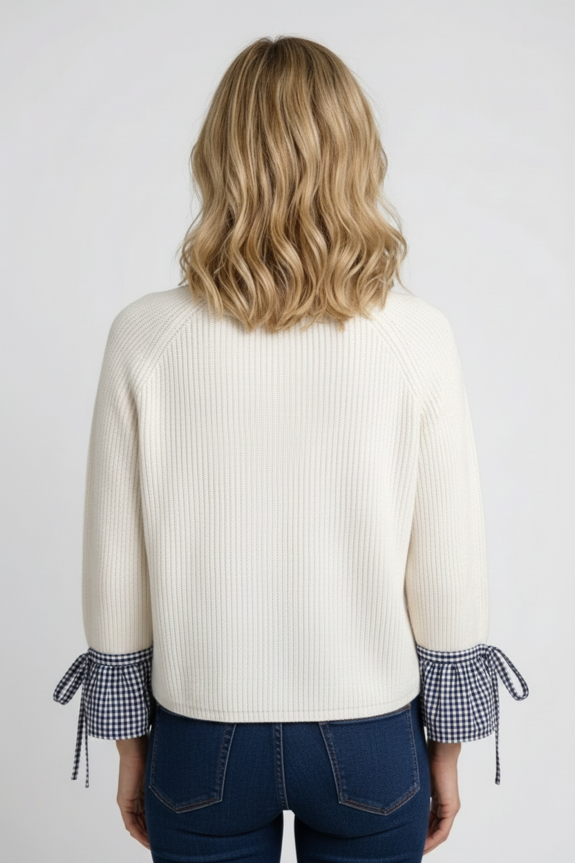 Woman wearing a white sweater with plaid cuffs back view