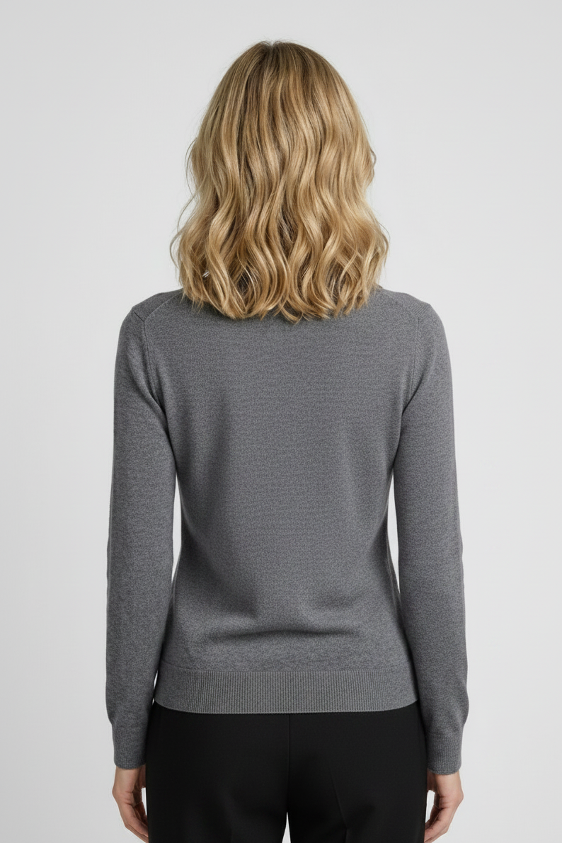 Person wearing a gray sweater and pants on a light gray background