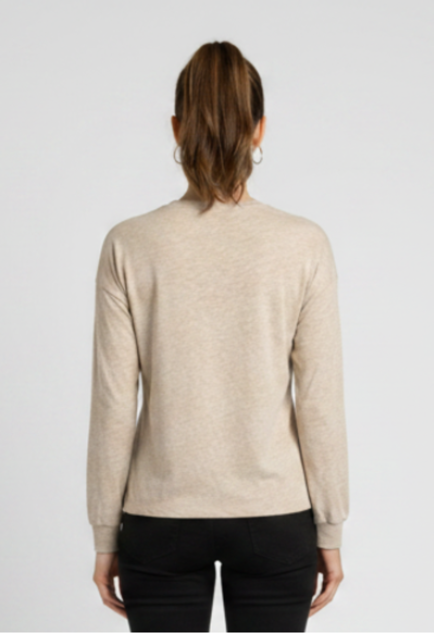 Woman wearing a beige sweater and black trousers