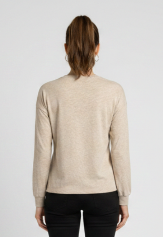 Woman wearing a beige sweater and black trousers