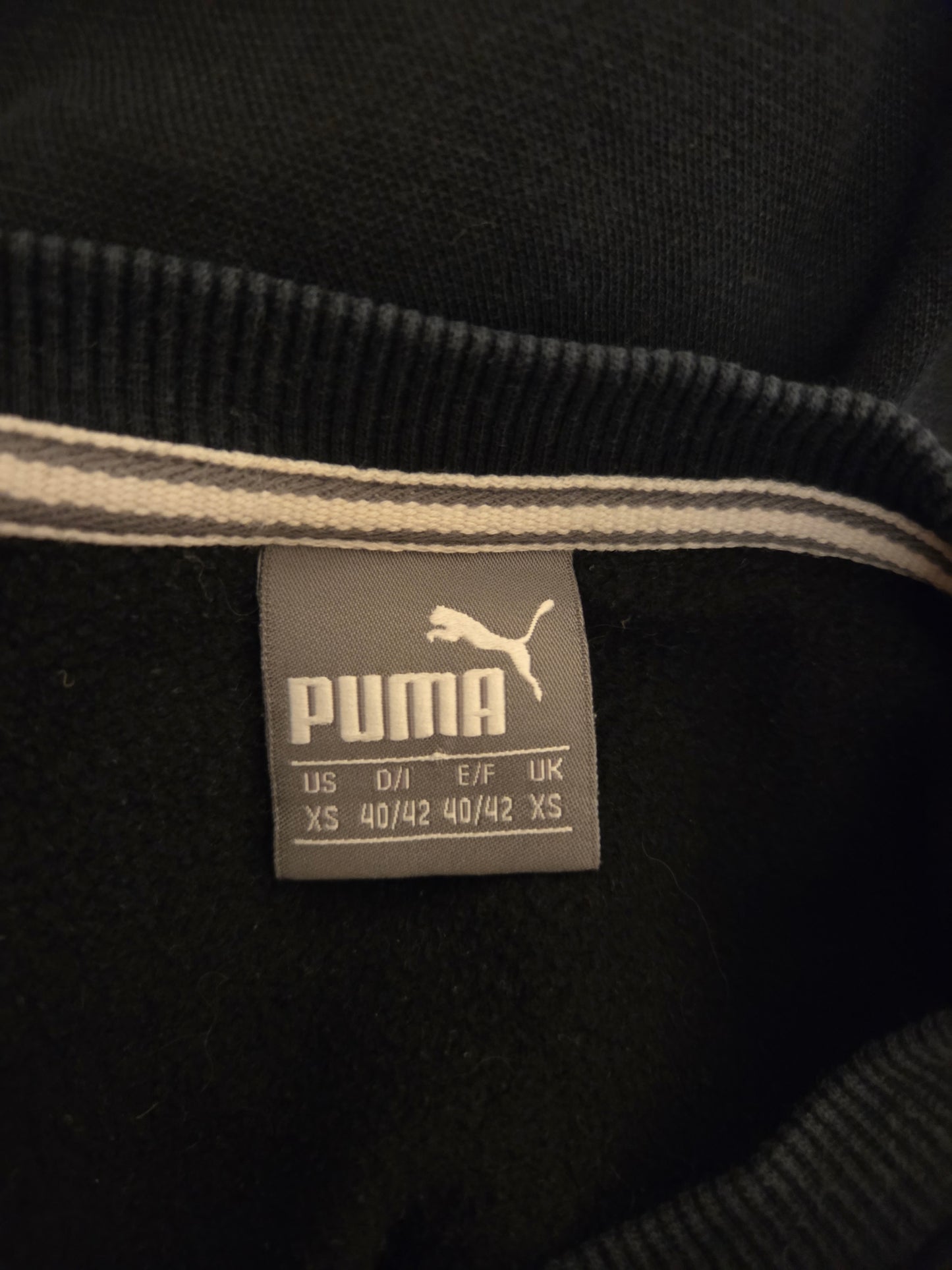 Puma label on a black sweatshirt with visible brand logo.