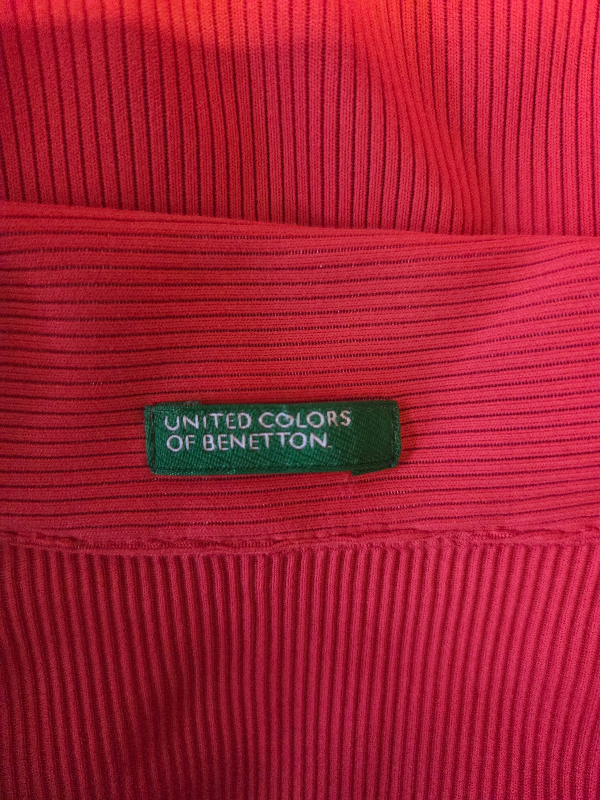 Red ribbed fabric with a green label reading 'United Colors of Benetton'.