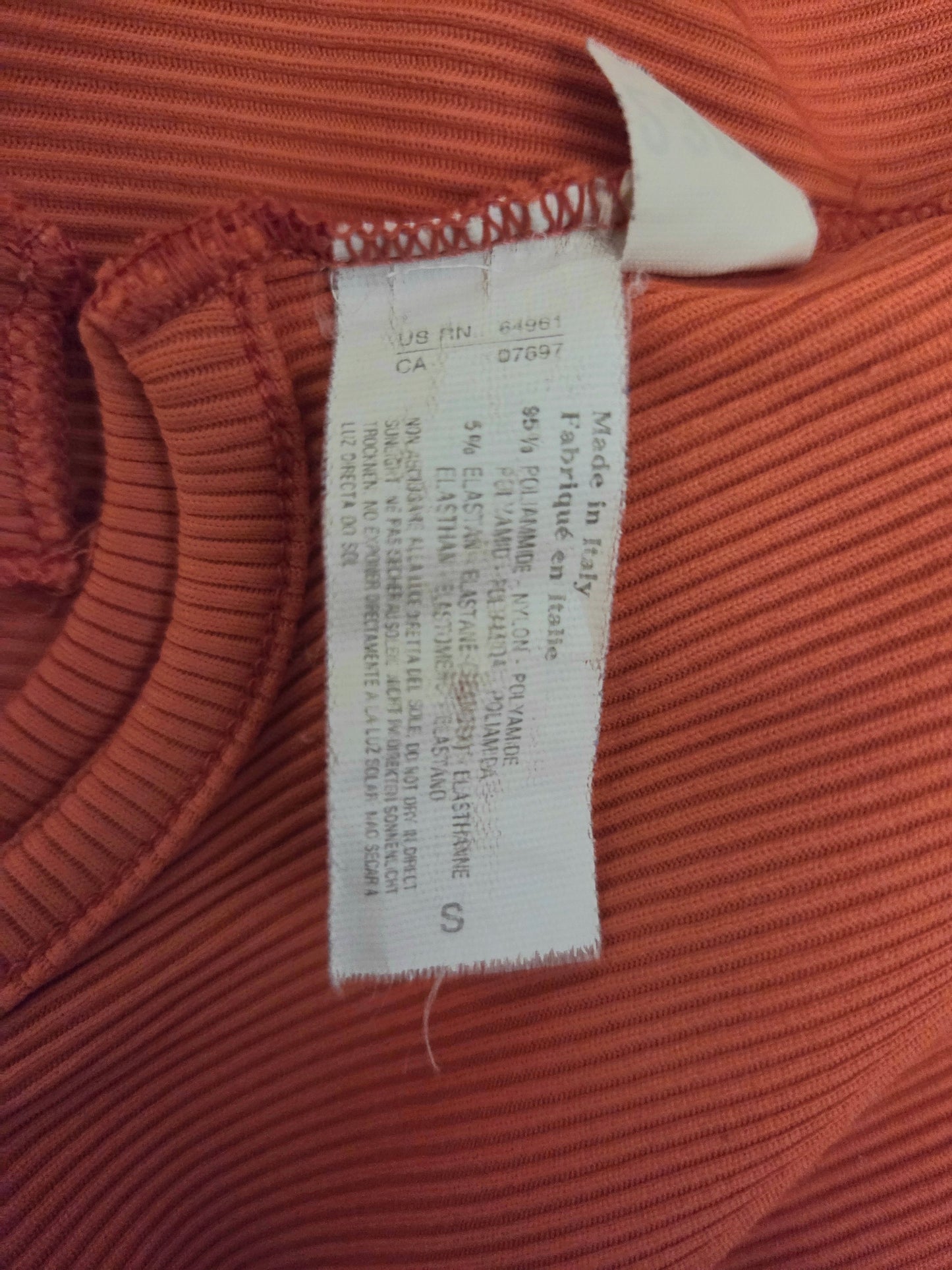 Close-up of a clothing tag on a ribbed fabric background