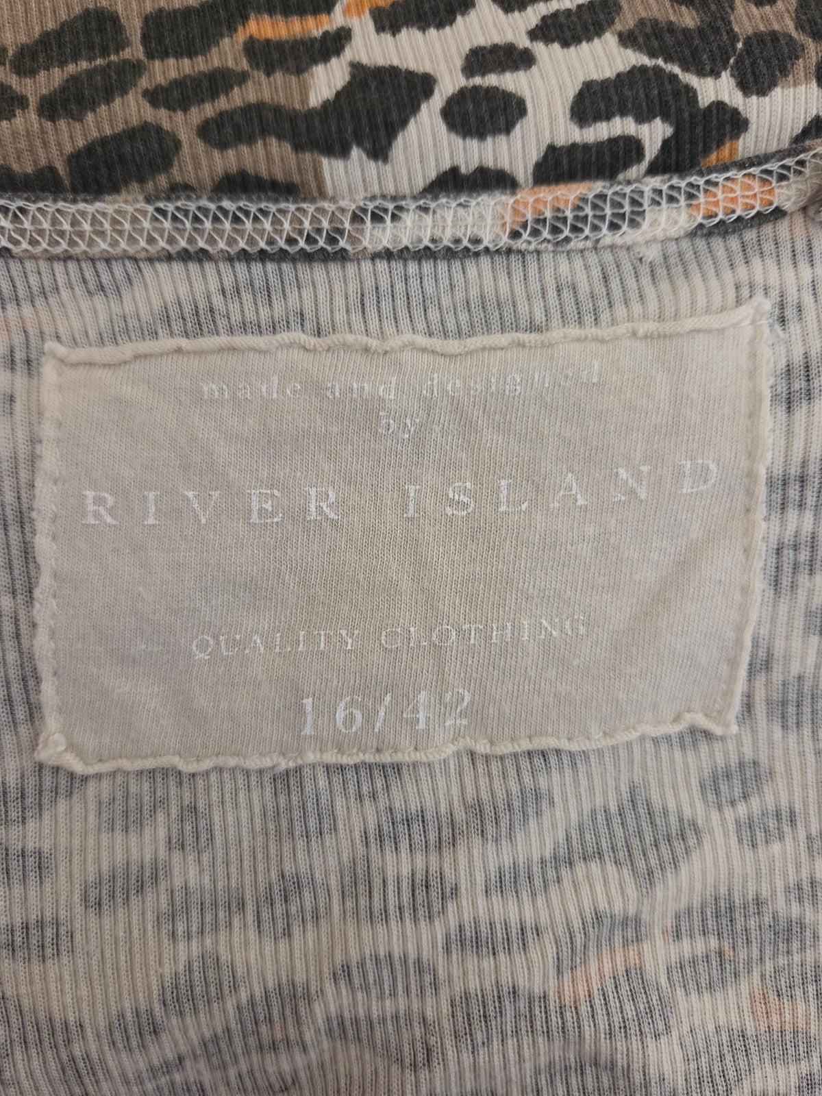 Close-up of a River Island size label on a garment with leopard print details.
