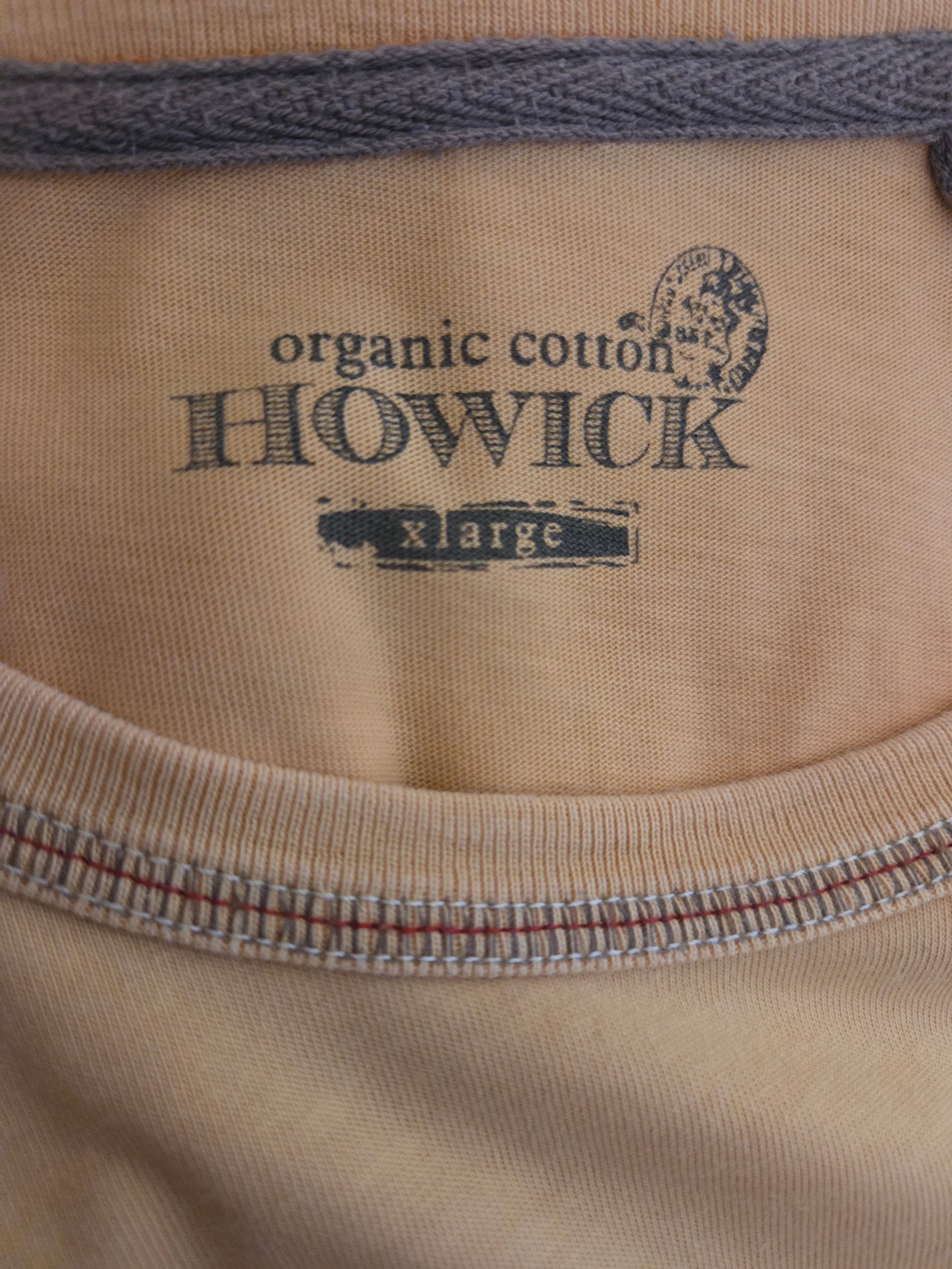 Close-up of a beige fabric with 'Howick' branding and stitching details.
